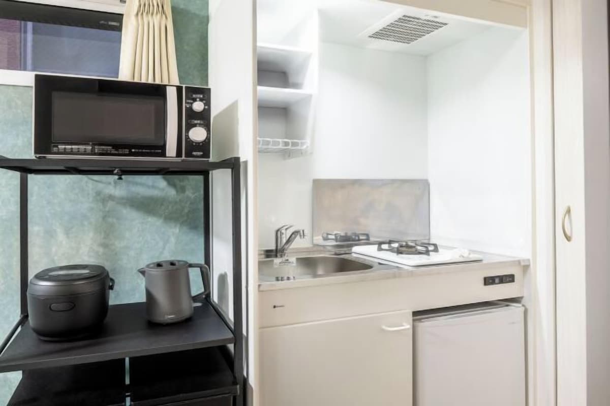 Cocina privada | Frigorífico pequeño, microondas, placa de cocina y hervidor eléctrico