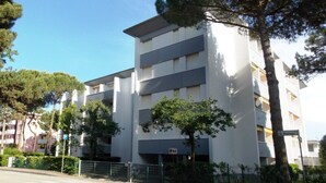Ein mehrstöckiges Gebäude mit modernem architektonischen Design, inklusive Balkonen und einem verschlossenen Eingang.