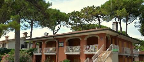 A two-story building with a central staircase, balconies, and a sign indicating it is a hotel.