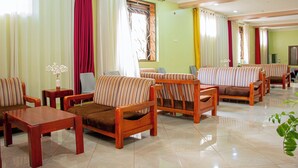Une chambre d’hôtel avec des canapés à rayures, une table basse en bois et un téléviseur.