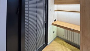 A modern interior with a sliding door, wooden shelves, and a herringbone-patterned floor. - NestOne SkyView (Тоshkent)