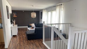 A modern living room with a dark sofa, a white coffee table, and a patterned wall. - Ronneby Torneryd Retreat (Ronneby)