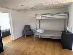 A bunk bed with a ladder, a grey armchair, and a desk with a lamp. - Ronneby Torneryd Retreat (Ronneby)