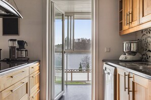 A kitchen with wooden cabinets, a coffee maker, a blender, and a dishwasher. - Ronneby Torneryd Retreat (Ronneby)