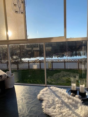 A room with large windows, a white furry rug, and candles on a tray. - Ronneby Torneryd Retreat (Ronneby)