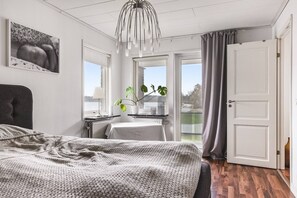 A bedroom with a bed, a desk, a potted plant, and a view of the outdoors. - Ronneby Torneryd Retreat (Ronneby)
