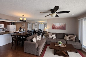 A modern living room with a sofa, coffee table, and dining area. - Shorefront Escape at TRL (Kimberling City)