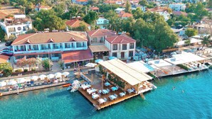 A waterfront property with a dock, outdoor seating, and a pool area. - Felix Rooms (Marmaris)
