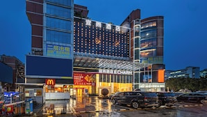 A hotel with a modern facade, large windows, and a prominent sign for E CHARM. - Echarm International Hotel Guangzhou Baiyun International Airport Huadu Plaza Branch - Free Deliver Service to Guangzhou Baiyun International Airport & Free Deliver Service to Canton Fair Complex During Canton Fair Period (Guangzhou)
