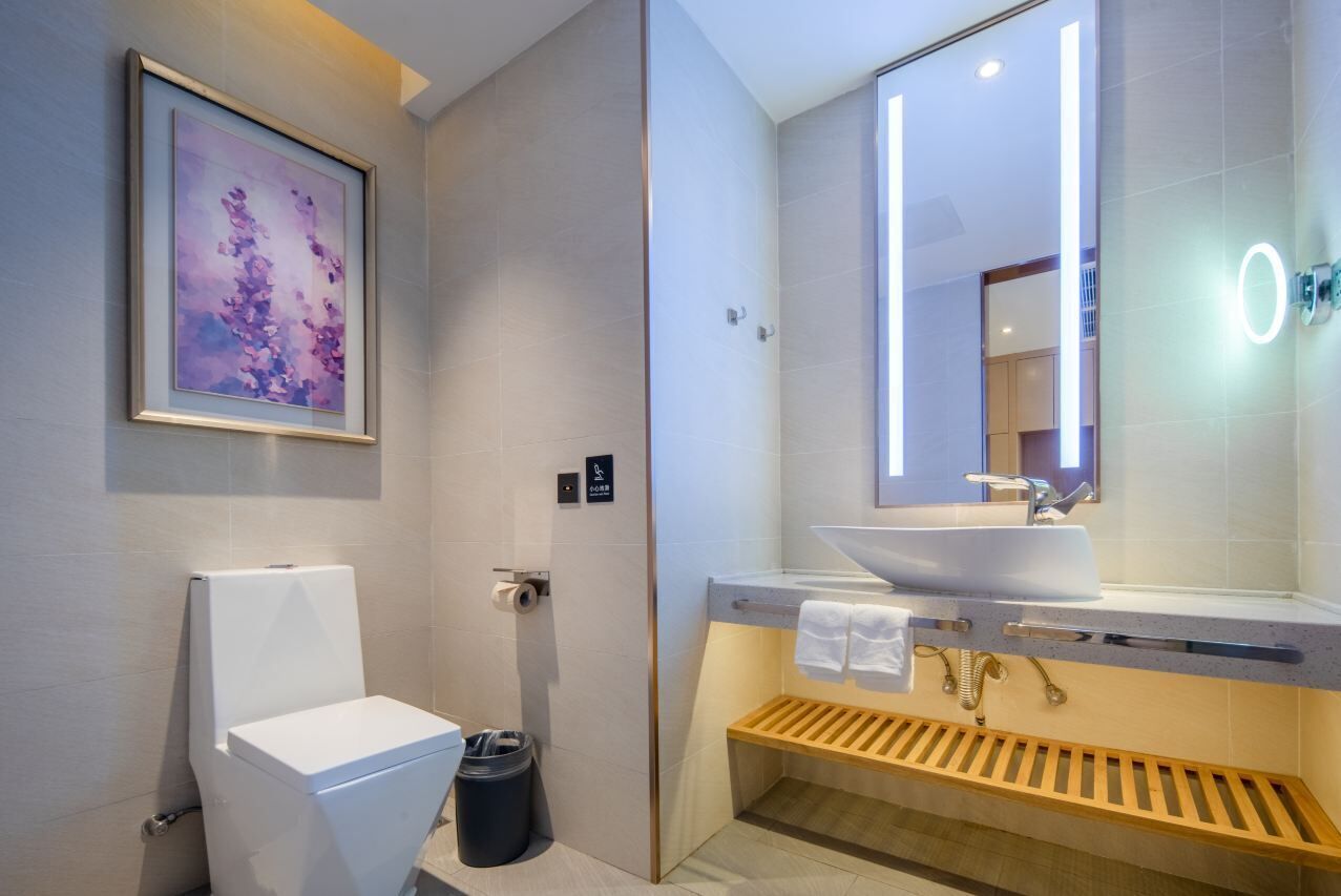 Un baño moderno con inodoro, lavamanos y ducha.