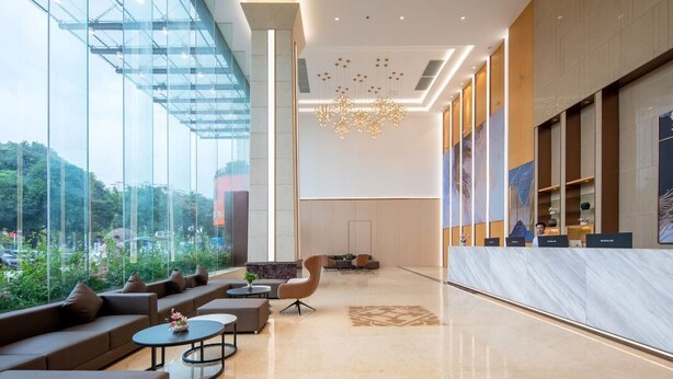 A modern lobby with a glass facade, a chandelier, and seating areas. - Echarm International Hotel Guangzhou Baiyun International Airport Huadu Plaza Branch - Free Deliver Service to Guangzhou Baiyun International Airport & Free Deliver Service to Canton Fair Complex During Canton Fair Period (Guangzhou)