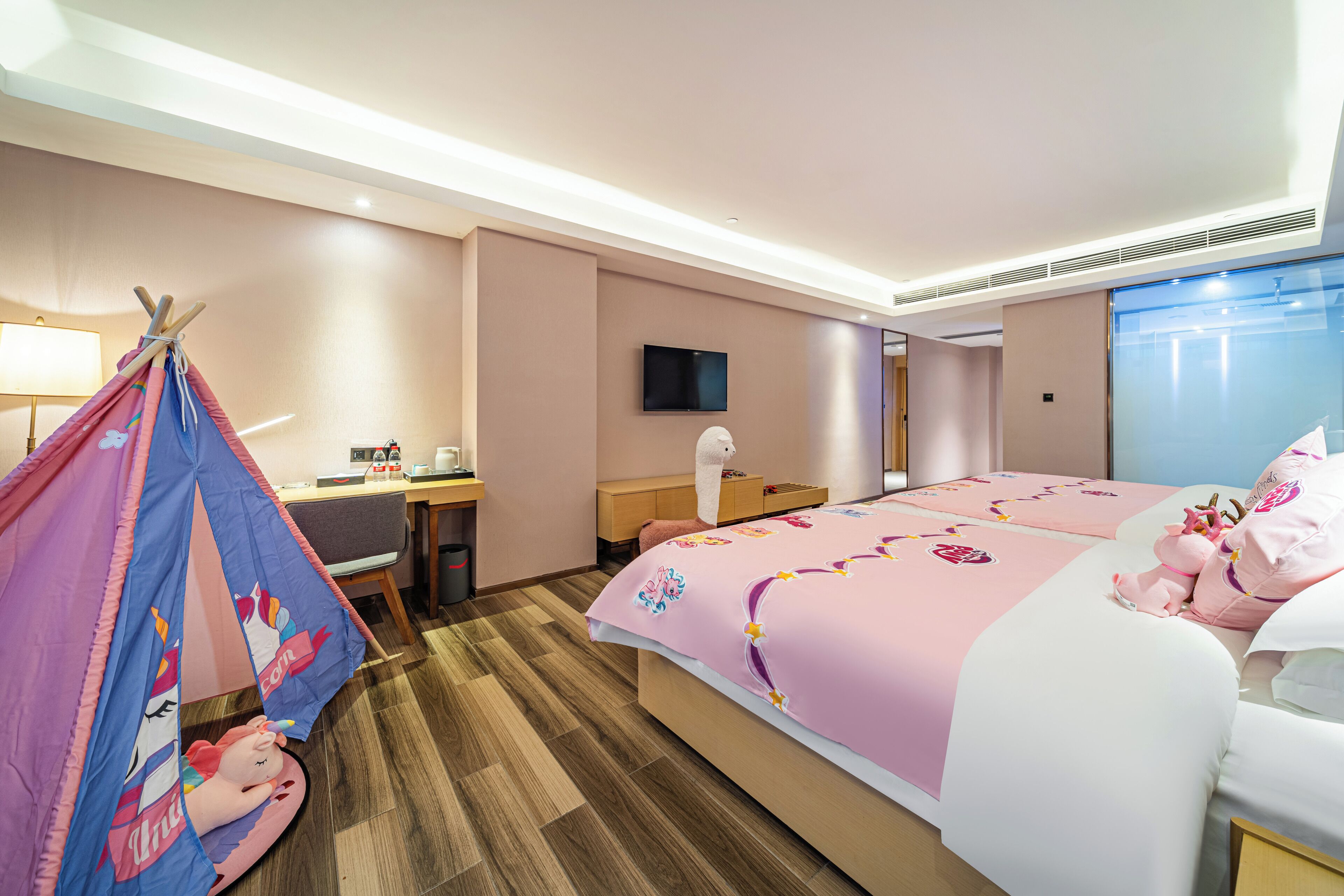 Ein Hotelzimmer mit Bett, Schreibtisch, Stuhl, Fernseher und Fenster.