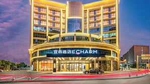 A hotel with a modern design, featuring a prominent central entrance and multiple floors. - Echarm Hotel Guangzhou Baiyun International Airport T3 Terminal Branch (Guangzhou)