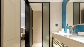 A modern bathroom with a large mirror, a white sink, and a towel rack. - Echarm Hotel Guangzhou Baiyun International Airport T3 Terminal Branch (Guangzhou)