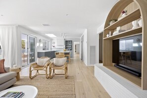 A modern living room with a sofa, a coffee table, and a fireplace.
