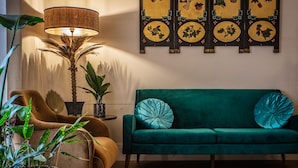 Una sala de estar con un sofá verde, una lámpara y una pared con paneles decorativos.