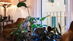 Una habitación con una planta grande en maceta, una lámpara y una silla.