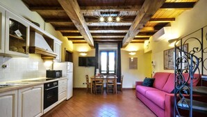 A kitchen with white cabinets, a microwave, and a dining area with a table and chairs.