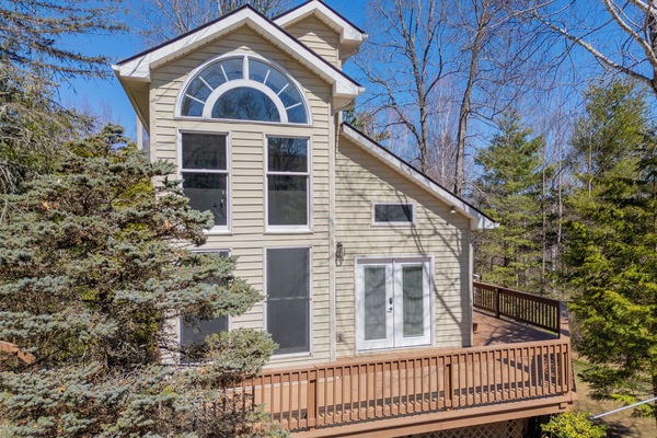 Charming cabin exterior with full deck and soaring windows.