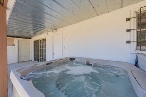 Ett område med ett bubbelbad, ett tak av metall, en dörr och ett fönster.