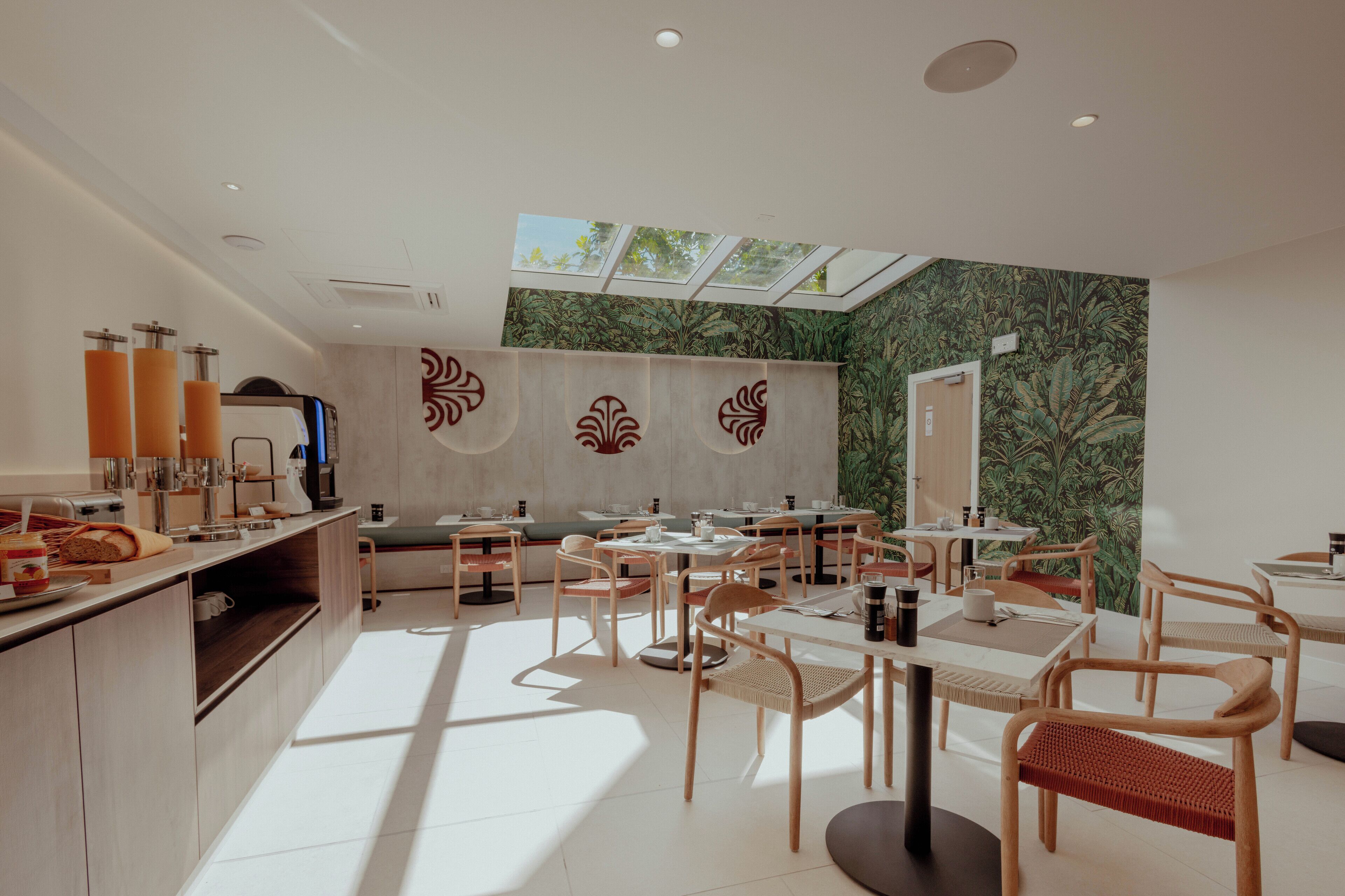 Un café moderne avec un plafond haut, une verrière et un espace salon équipé de tables et de chaises.