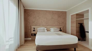 A modern hotel room with a large bed, wooden headboard, and a nightstand with a lamp.