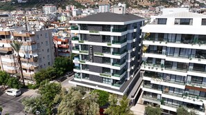 Ein mehrstöckiges Gebäude mit Balkonen, modernem Architekturstil und Blick auf die umliegende Stadtlandschaft.