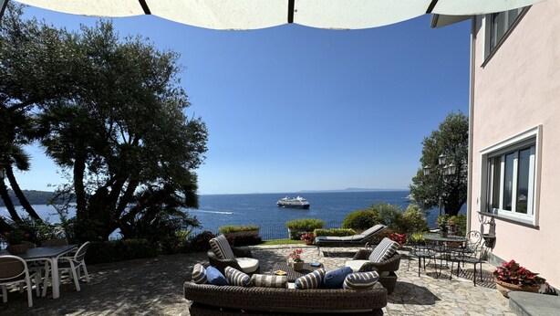A patio with wicker furniture, a stone floor, and a view of the sea. - Villa Saran, amazing seafront in Sorrento center (Sorrento)