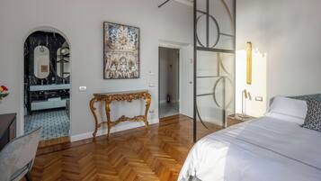 Une chambre à coucher moderne avec un grand lit, une coiffeuse avec un miroir et un tableau accroché au mur.