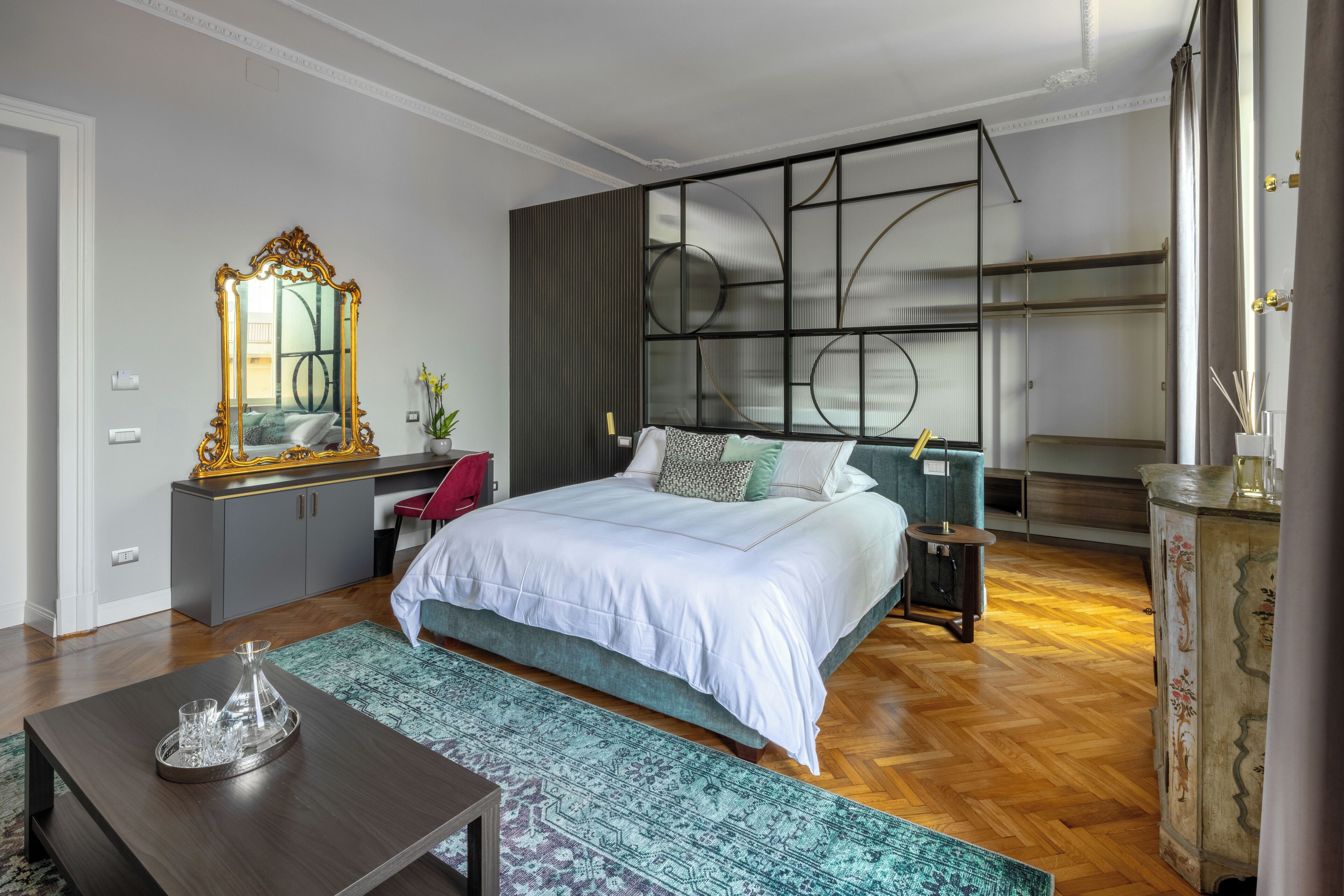 A bedroom with a large bed, a dresser, a mirror, and a nightstand.