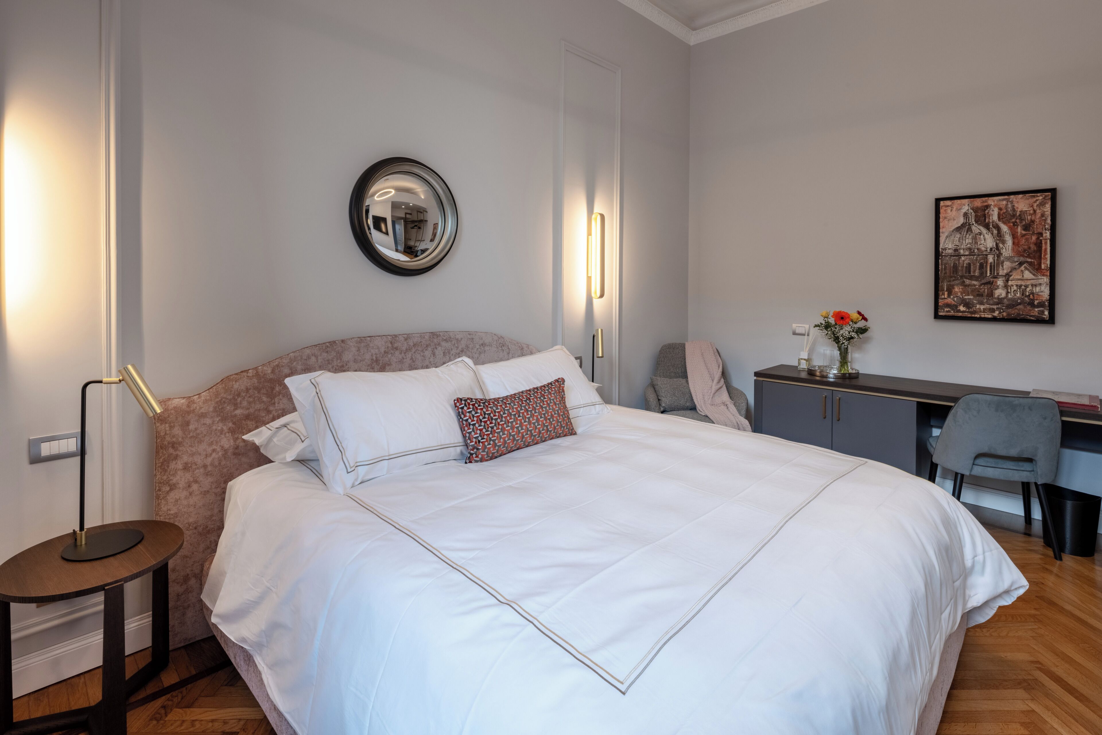 Ein ordentlich eingerichtetes Schlafzimmer mit einem großen Bett, Nachttisch, Schreibtisch und Stuhl.