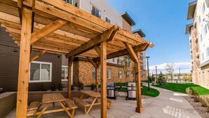 Un espace extérieur abrité, équipé de tables de pique-nique et de barbecues.