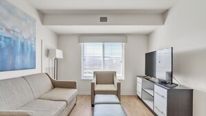 A modern living room with a sofa, a chair, a TV, and a cabinet. - Simplicity At the Rim 1216 I Comfy 2 Bed 2 Bath (San Antonio)