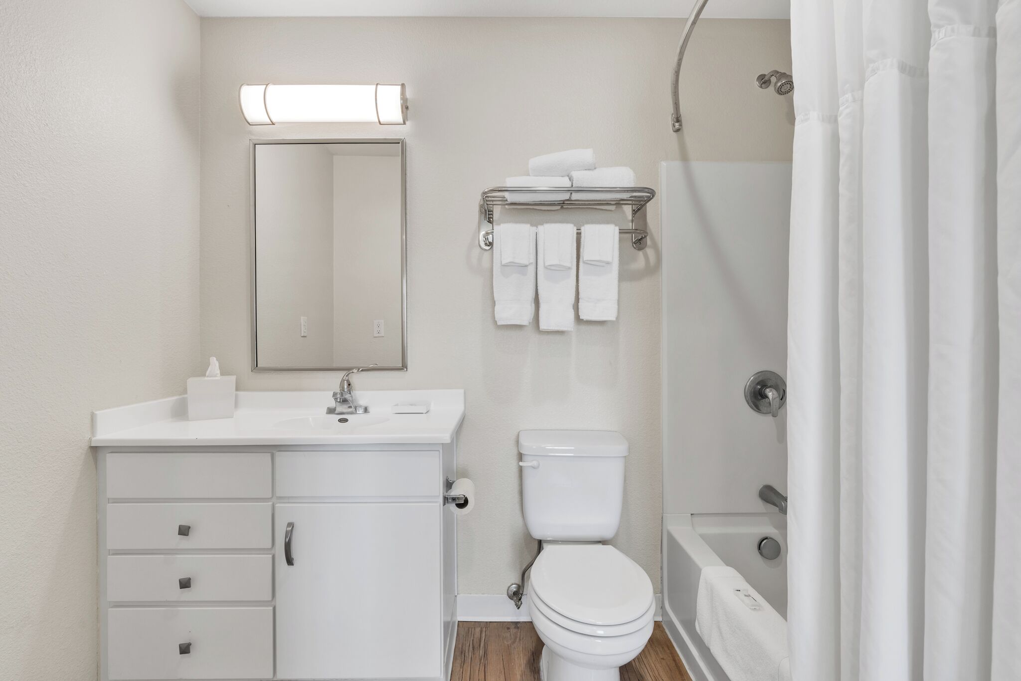 A modern bathroom with a toilet, sink, and shower.