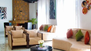 Una sala de estar moderna con sofás, una mesa de centro y obras de arte en las paredes.