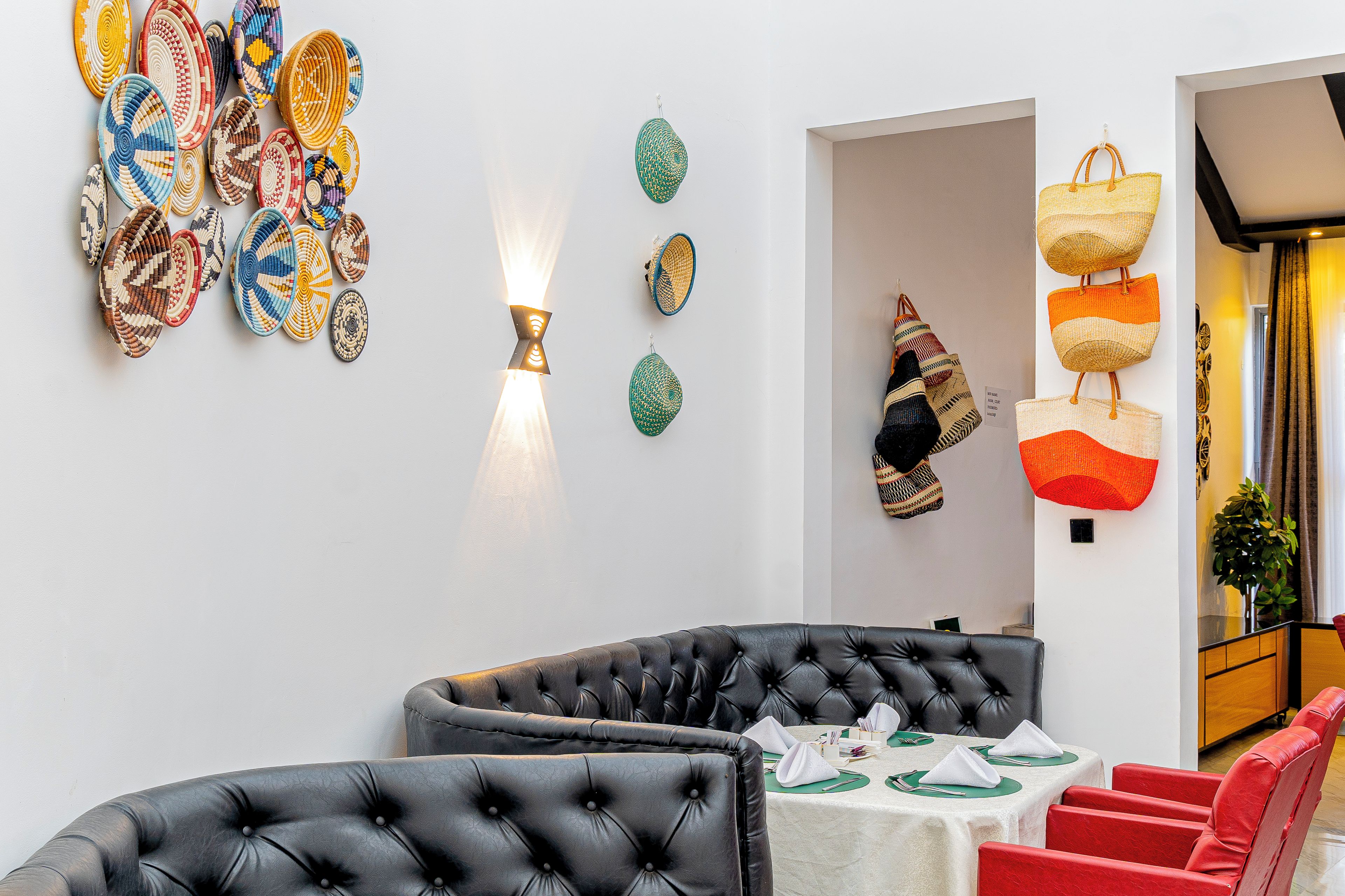 Ein Essbereich mit einer schwarzen Ledersofa, roten Stühlen und einem für das Essen gedeckten Tisch.