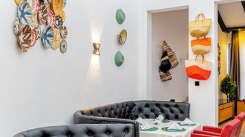Ein Essbereich mit einer schwarzen Ledersofa, roten Stühlen und einem für das Essen gedeckten Tisch.