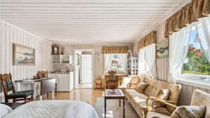 Una habitación acogedora con una cama, un sofá, una mesa de comedor y una zona de cocina.