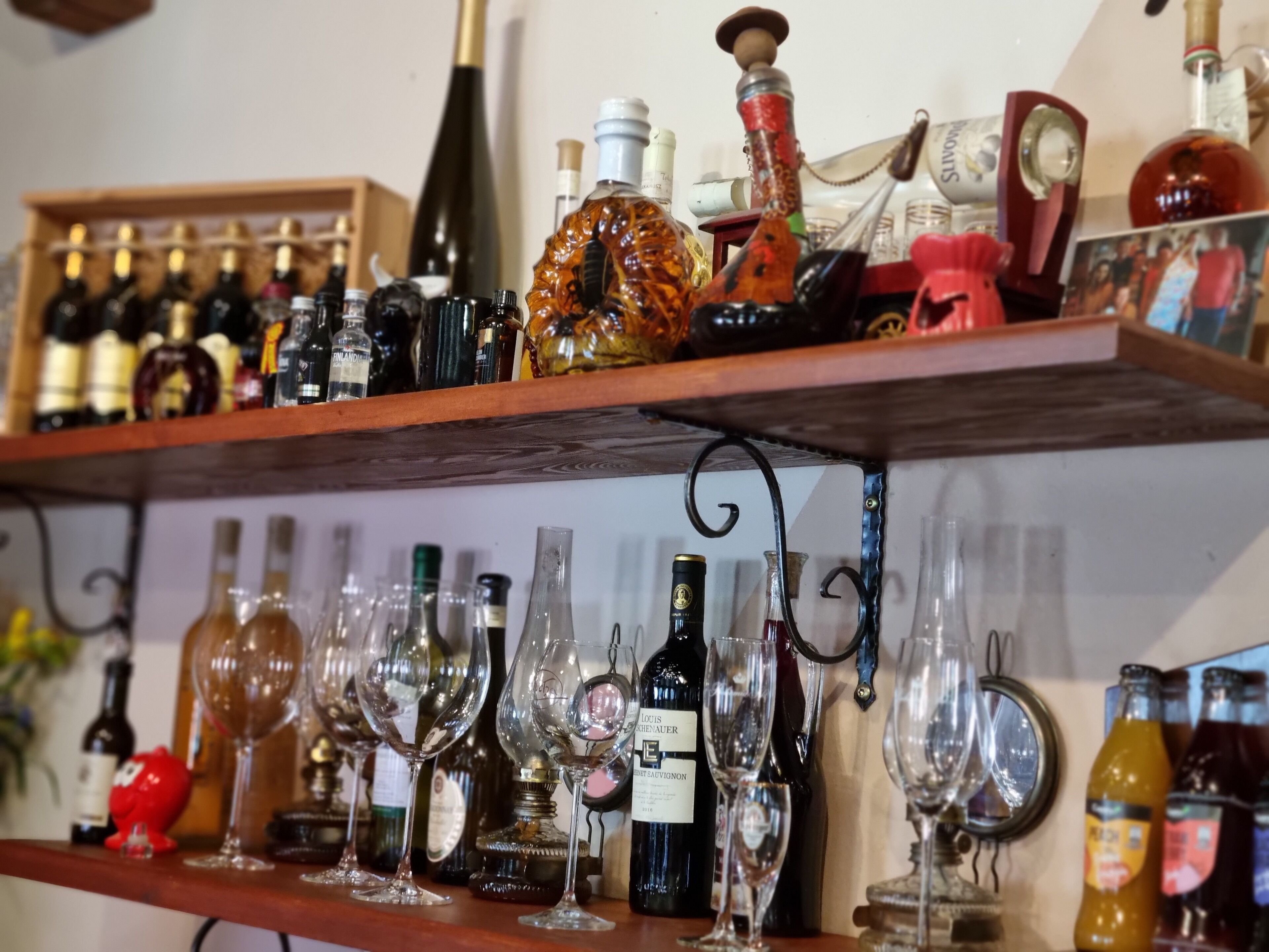 Zona de bar con estantes llenos de botellas y copas.