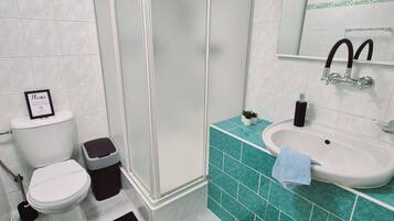 Une salle de bain équipée de toilettes, d’un bidet et d’une douche.