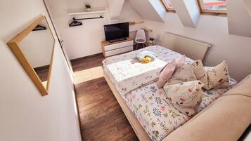 Une chambre à coucher avec un lit, une télévision, un bureau et une fenêtre.