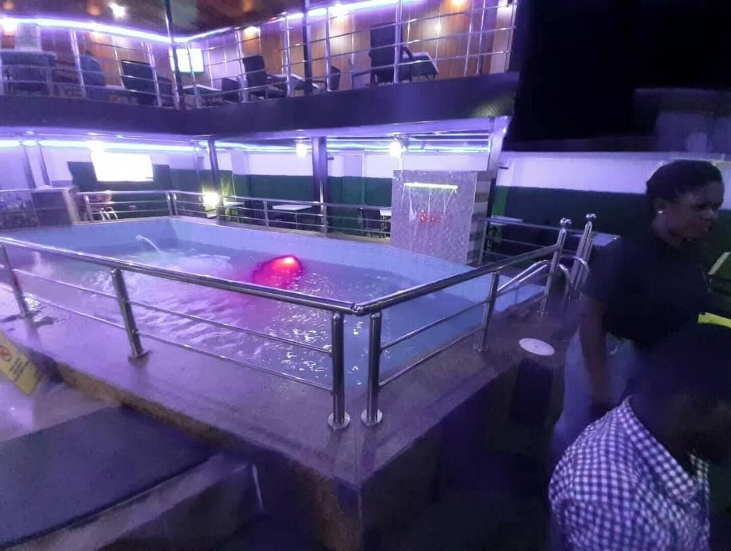 Un espace piscine agrémenté d’une barrière en verre et de rampes métalliques.