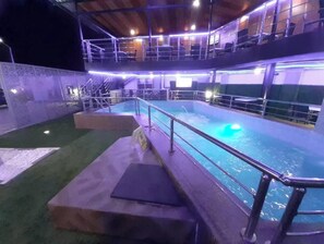Ein Innenpool mit Glastrennwand und Treppen zu einer Aussichtsplattform.