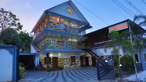 A multi-story hotel with a prominent sign, a staircase, and a gated entrance. - The Svarga Hill View Resort (Devikolam)