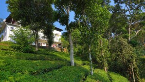 A lush garden with neatly trimmed hedges and a variety of trees. - The Svarga Hill View Resort (Devikolam)