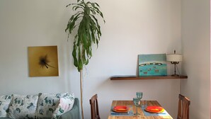 A dining area with a wooden table, chairs, a potted plant, a painting, and a lamp. - Bright & Pop Flat Isola & Central Station Hub (Milan)