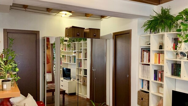 Un salon avec un canapé rouge, une table basse en bois et une bibliothèque.