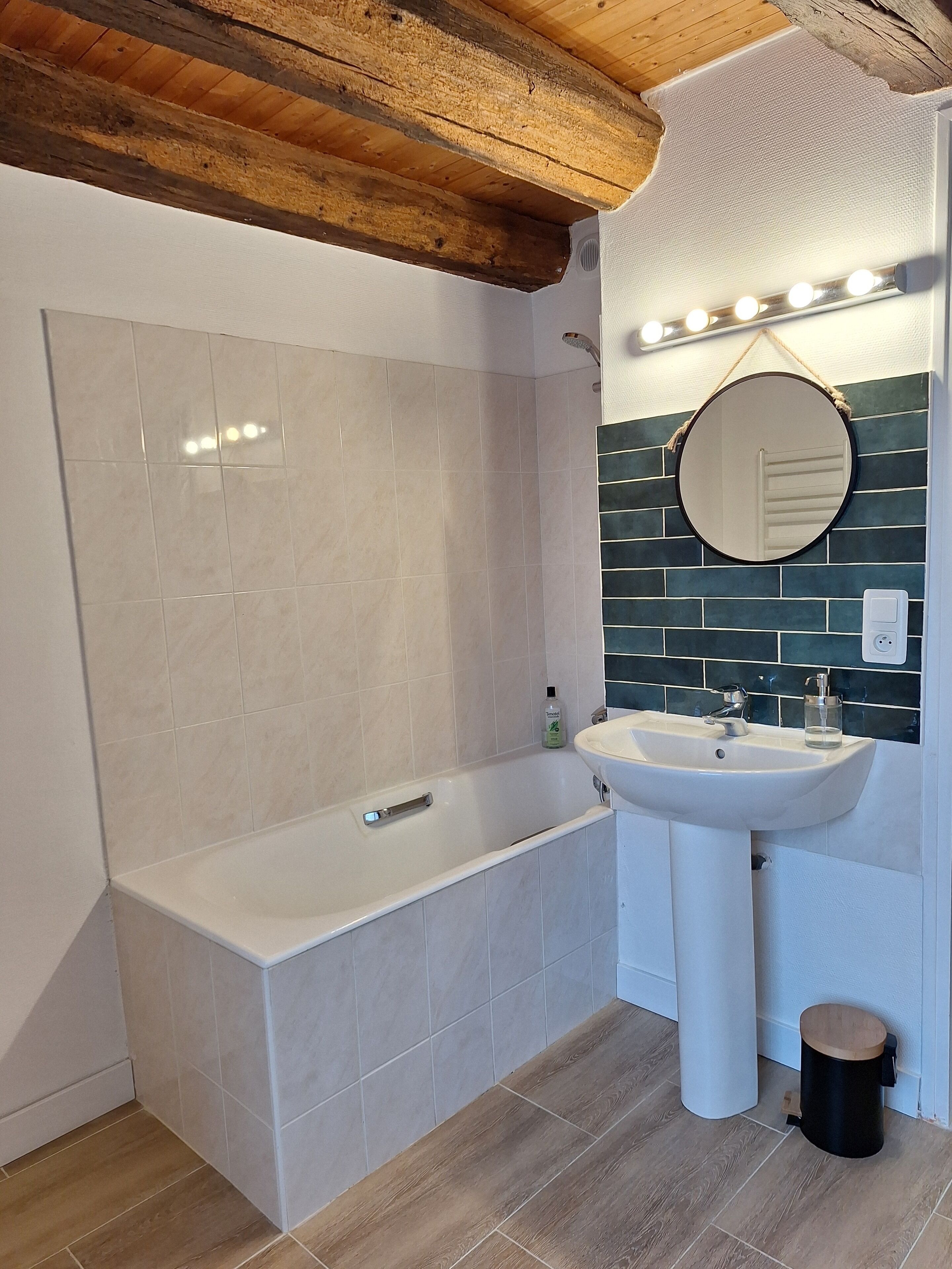 A modern bathroom with a bathtub, sink, and mirror.