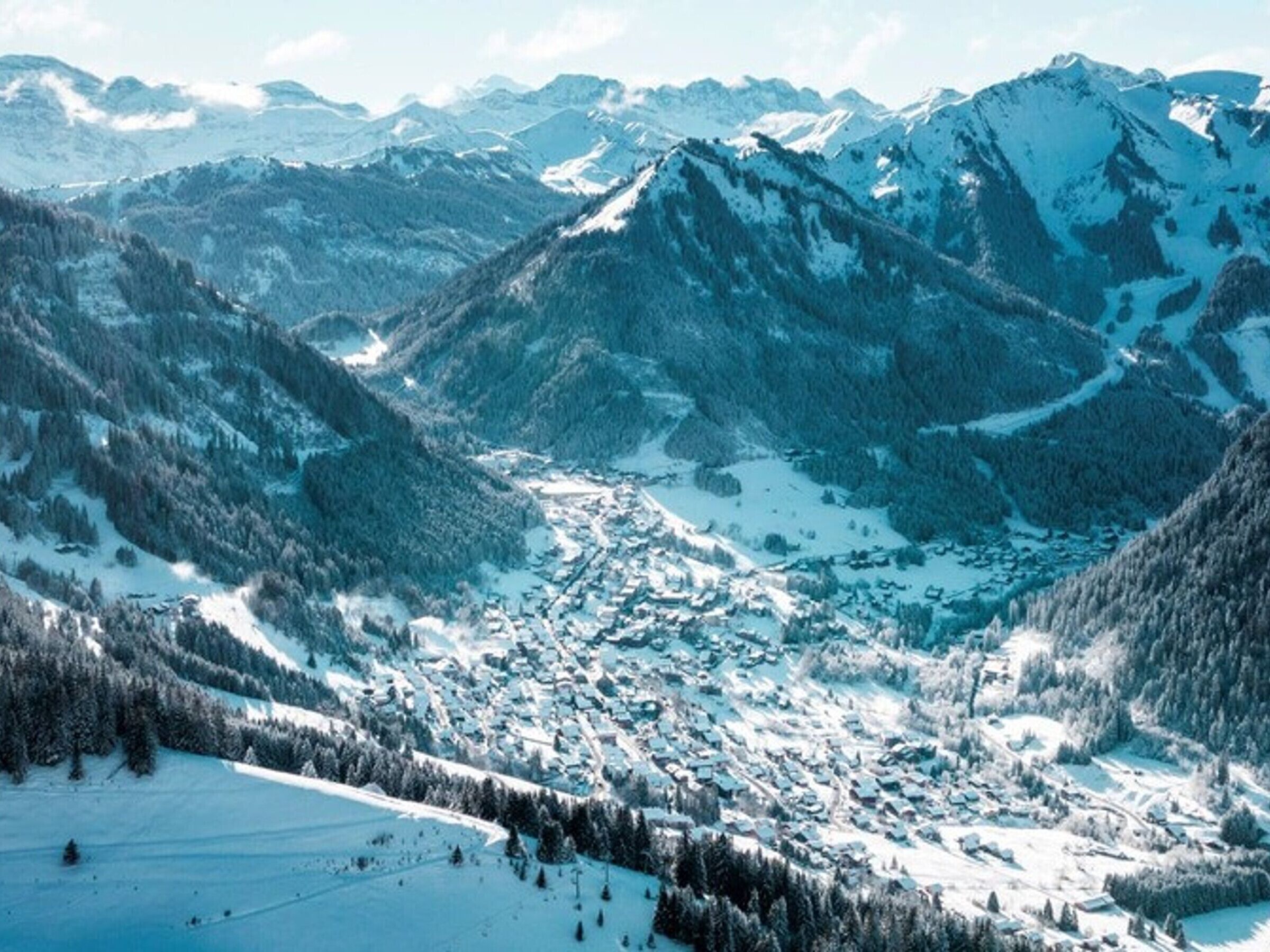 Un paysage montagneux comprenant une vallée et un petit village.