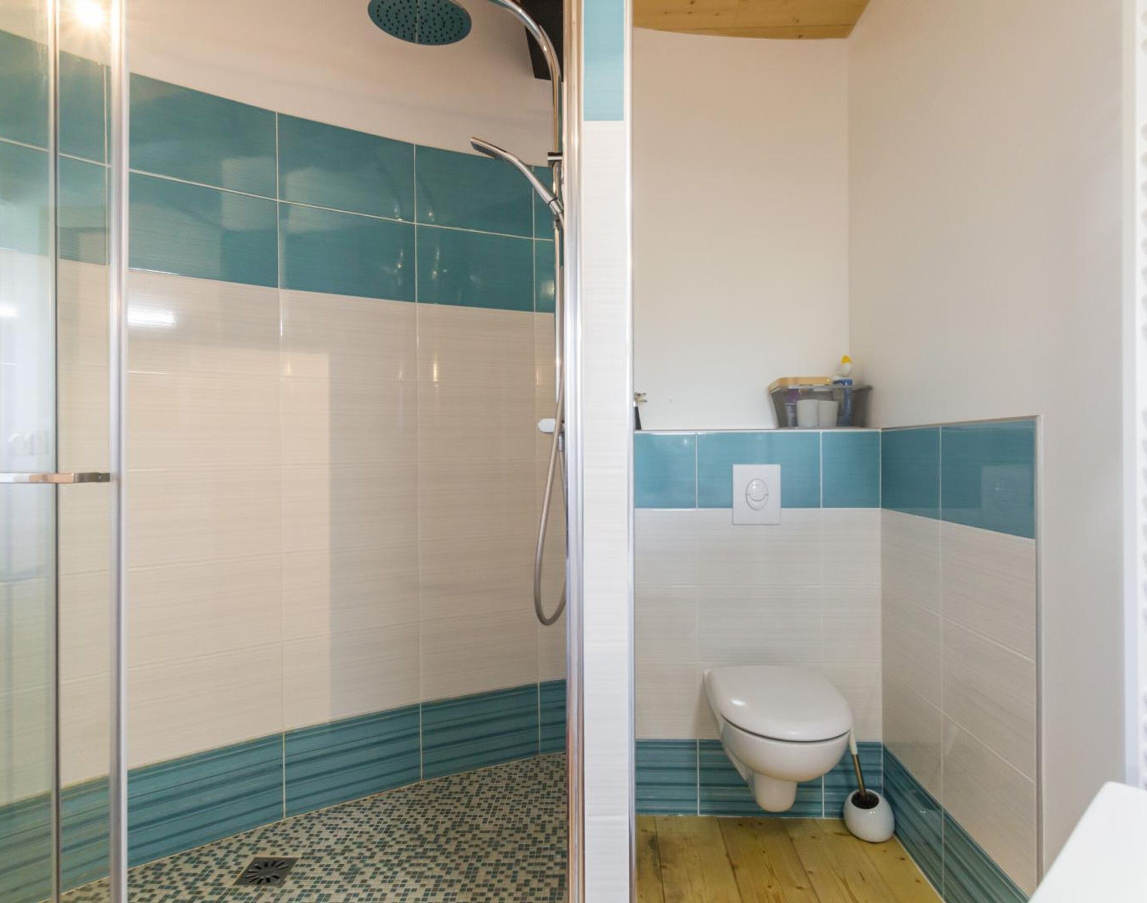 A bathroom with a glass-enclosed shower, a toilet, and a sink.